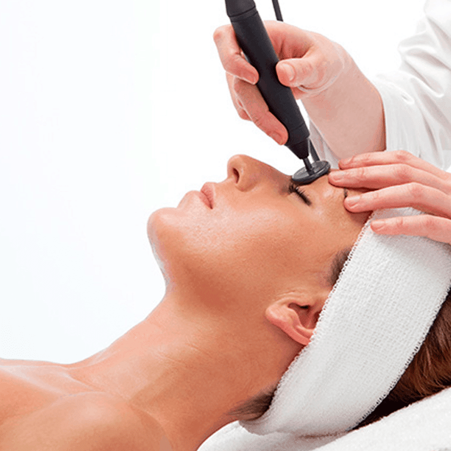Diatermia Facial. Mujer aplicándose tratamiento con aparatología. Centro de estética y belleza en Terrassa